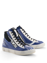 Sapatos Alpinestars Stated Flair, sapatos de motociclismo urbanos, azul brilhante, branco e preto, estética racing clássica com efeito de desgaste aplicado à mão na sola, construção em pele premium com detalhes perfurados e fecho lateral.