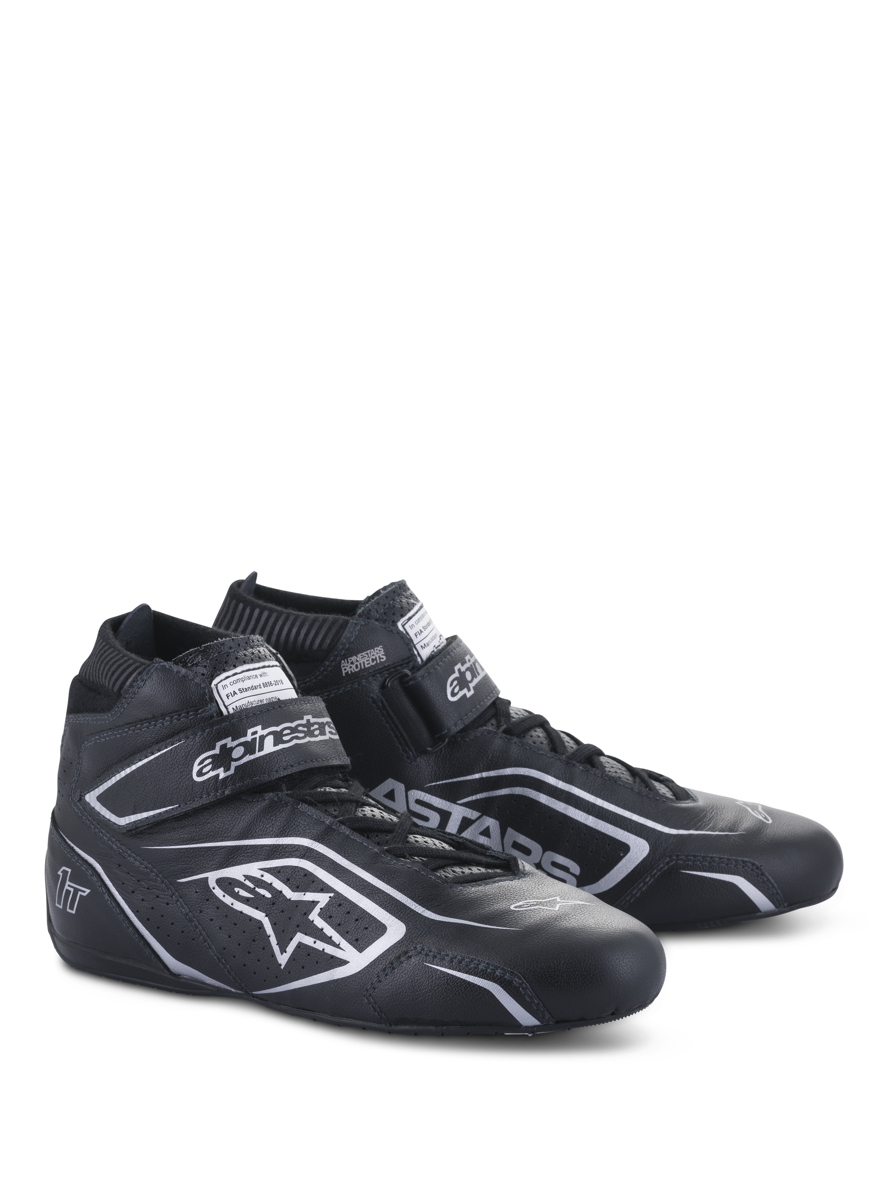 Sapatos Alpinestars Tech-1 T V3 FIA, sapatos de automobilismo, pretos e prateados, construção em couro bovino com logótipos e branding Alpinestars prateados, vista lateral angulada com tira de gancho e laço e fecho de cadarços