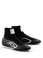 Sapatos Alpinestars Supertech K - FIA, sapatos de karting, pretos e brancos, parte superior totalmente em malha com ajuste tipo meia de cano alto, logótipo Alpinestars branco na lateral, etiqueta branca de certificação FIA na língua, design leve e elegante para performance em corrida