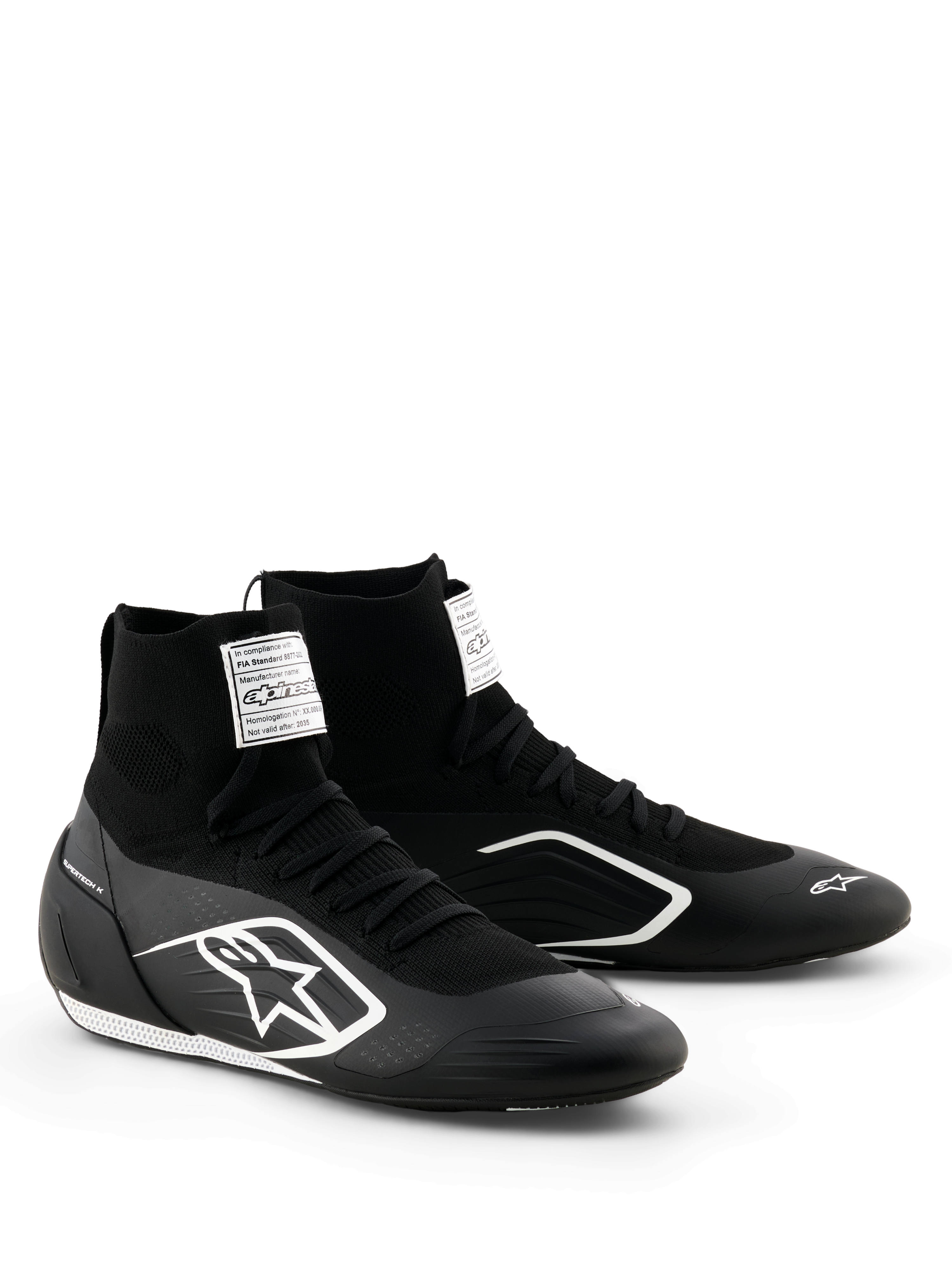Sapatos Alpinestars Supertech K - FIA, sapatos de karting, pretos e brancos, parte superior totalmente em malha com ajuste tipo meia de cano alto, logótipo Alpinestars branco na lateral, etiqueta branca de certificação FIA na língua, design leve e elegante para performance em corrida