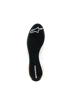 Sapatos Alpinestars Supertech K - FIA, vista inferior mostrando a sola de borracha preta ultra-fina, padrão de rasto assimétrico para aderência, logótipo e marca nominativa Alpinestars em branco, detalhes laterais dourados e brancos, calçado especializado para karting