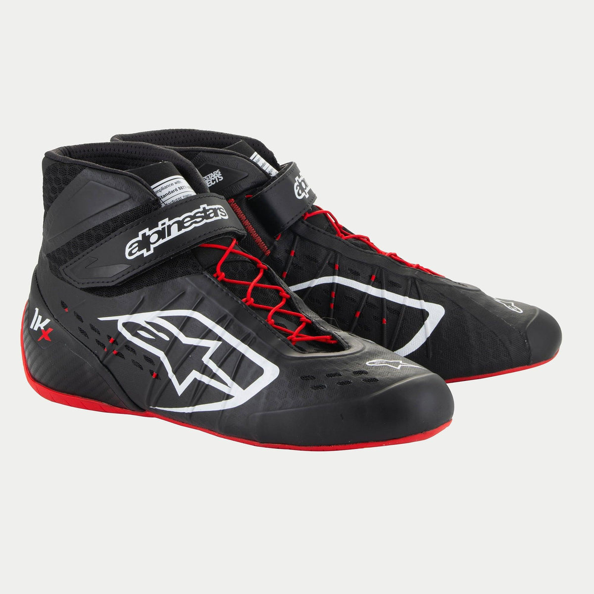 Sapatos Alpinestars Tech-1 KX V3, sapatos de karting, pretos, brancos e vermelhos, com logótipos Alpinestars brancos, atacadores assimétricos vermelhos e sola exterior vermelha, construção termossoldada elegante com perfurações cortadas a laser e tiras de tornozelo ajustáveis para performance no desporto motorizado.