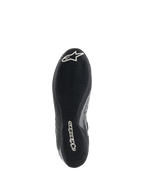 Sapatos Alpinestars Tech-1 Z V3 FIA, vista da sola do sapato de corrida preto e prateado, com sola exterior fina em borracha derivada da F1 e padrão de piso assimétrico, logótipos brancos incluindo o logo Astar e a marca nominativa Alpinestars