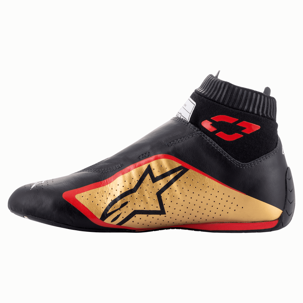 Sapatos Alpinestars Supermono V2 FIA, sapatos de automobilismo, preto, dourado e vermelho, vista lateral de perfil com uma construção elegante em couro de peça única, painel lateral dourado com logótipo de estrela preto, detalhes em vermelho e colarinho elástico canelado.