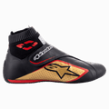 Alpinestars Supermono V2 Shoes FIA, sapatos de competição automóvel, pretos, dourados e vermelhos, vista de perfil lateral exibindo a construção em pele com painéis perfurados, grande logótipo de estrela dourada, colarinho elástico à prova de fogo tipo meia e uma tira de fecho de gancho e laço.