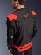 Casaco Alpinestars T-Stunt Air, preto, vermelho fluo e vermelho escuro, vista traseira num modelo, apresentando mangas em malha com protetores de cotovelo com textura em favo de mel, logótipo de estrela na parte superior das costas e marca 'RACING AHEAD' na zona lombar, design modular de corte desportivo para motociclismo