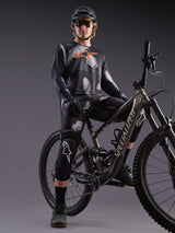 Alpinestars A-Dura Ride black camo jersey and shorts set, worn by a mountain bike rider with helmet and knee pads.