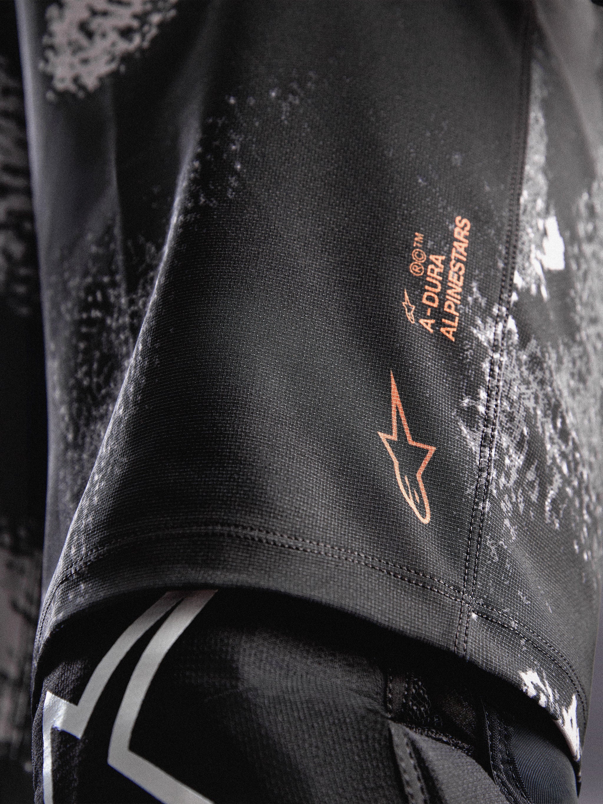 A-Dura Ride Shorts in Black Camo, featuring an orange Alpinestars logo on durable 4-way stretch woven fabric for MTB.