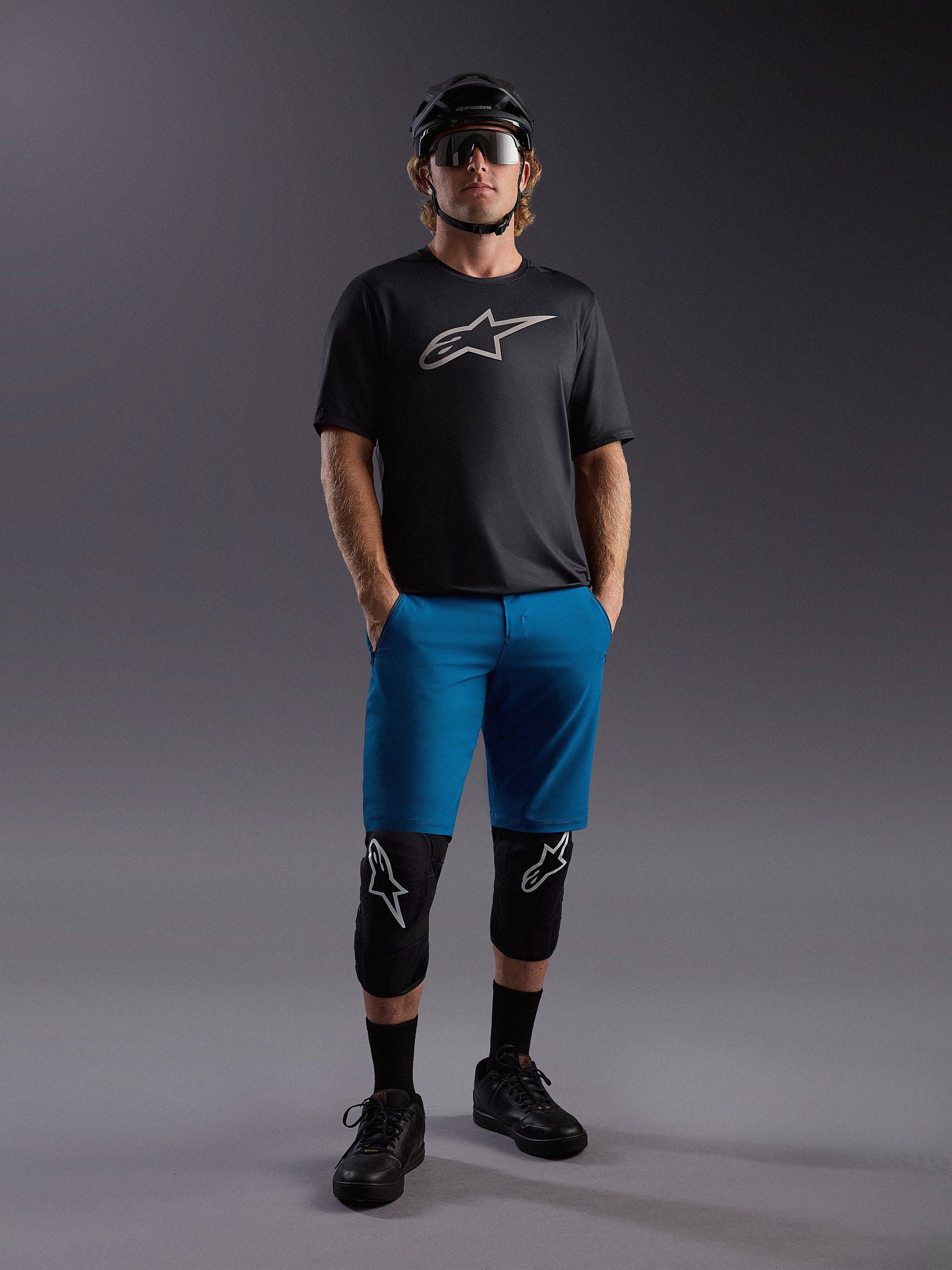 Jersey Alpinestars A-Dura Ride SS e calções azuis, conjunto completo de BTT com proteções e capacete.