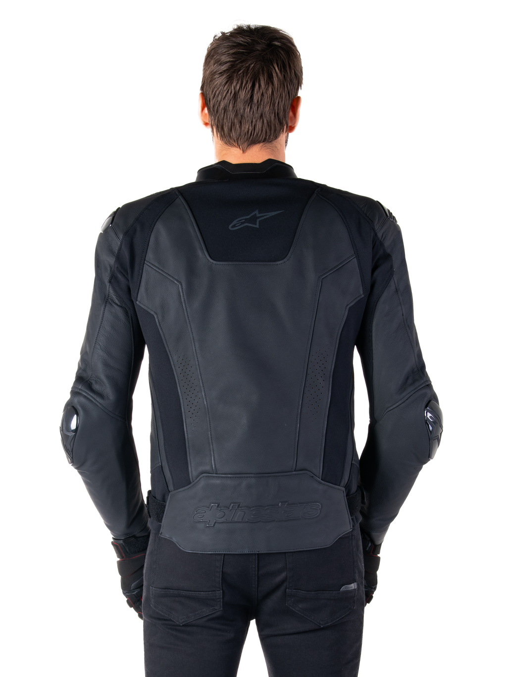 Rear view of a rider wearing the Alpinestars Missile V3 Leather Jacket in black, featuring premium leather construction with technical stretch panels, embossed Alpinestars logo on the lower back, and subtle branding on the upper back, paired with black pants for a coordinated racing sport look.