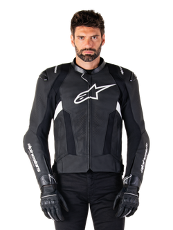 Casaco de pele Alpinestars Missile V3, preto com logótipos brancos, usado por um modelo com luvas de condução pretas, casaco de corrida de motociclismo em pele premium com painéis de ventilação perfurados e características de condução de alto desempenho