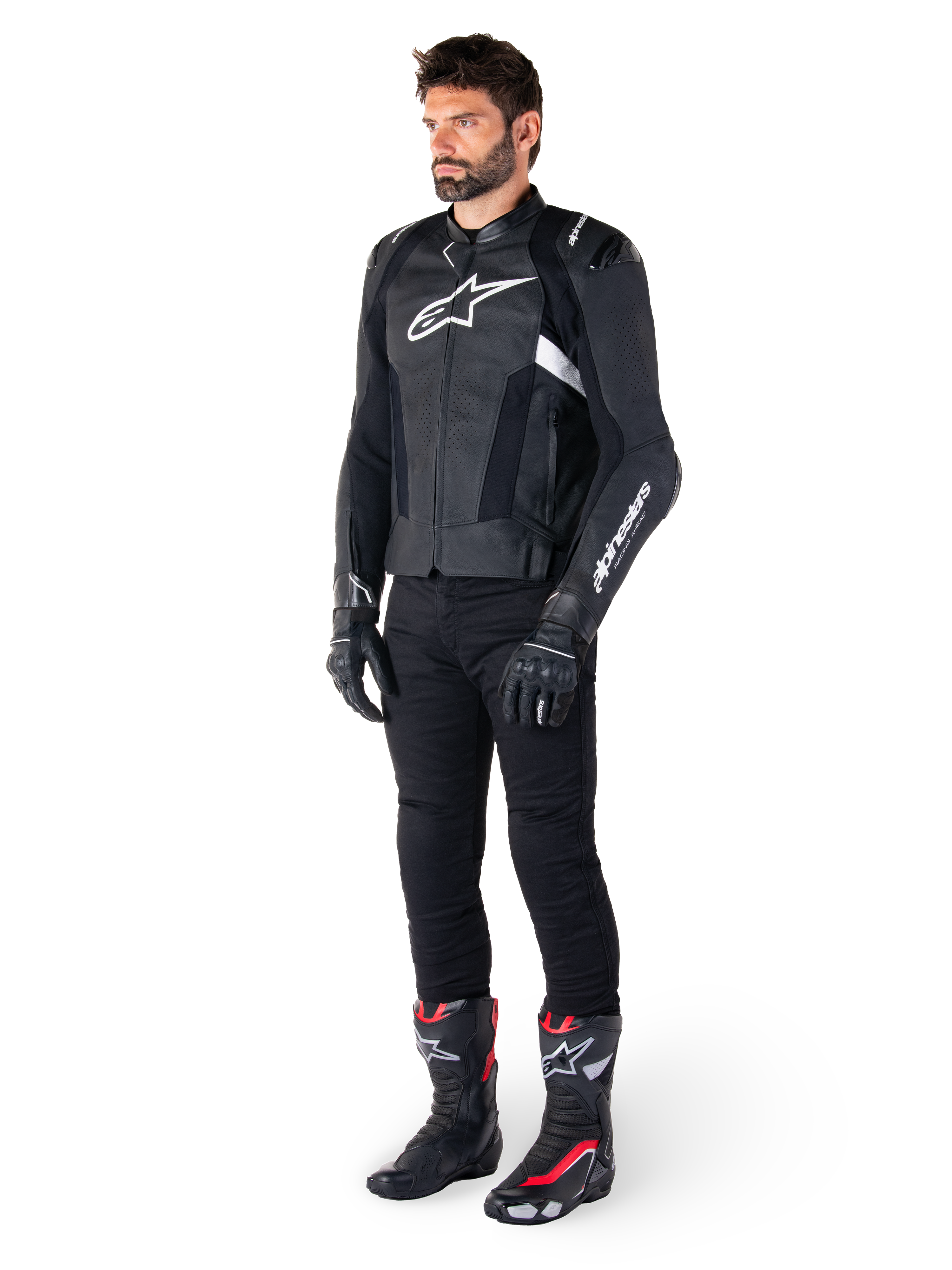 Male rider wearing the Alpinestars Missile V3 Leather Jacket in Black and White, featuring a white chest logo and perforated leather panels, paired with black riding pants, black gloves, and black and red racing boots for a complete sport riding look.