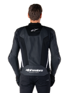 Alpinestars Missile V3 Airflow Leather Jacket, Black and White, back view worn by a rider, featuring extensive perforated leather panels, white side accents, Alpinestars star logo on the upper back, and 'alpinestars RACING AHEAD' branding on the lower back.