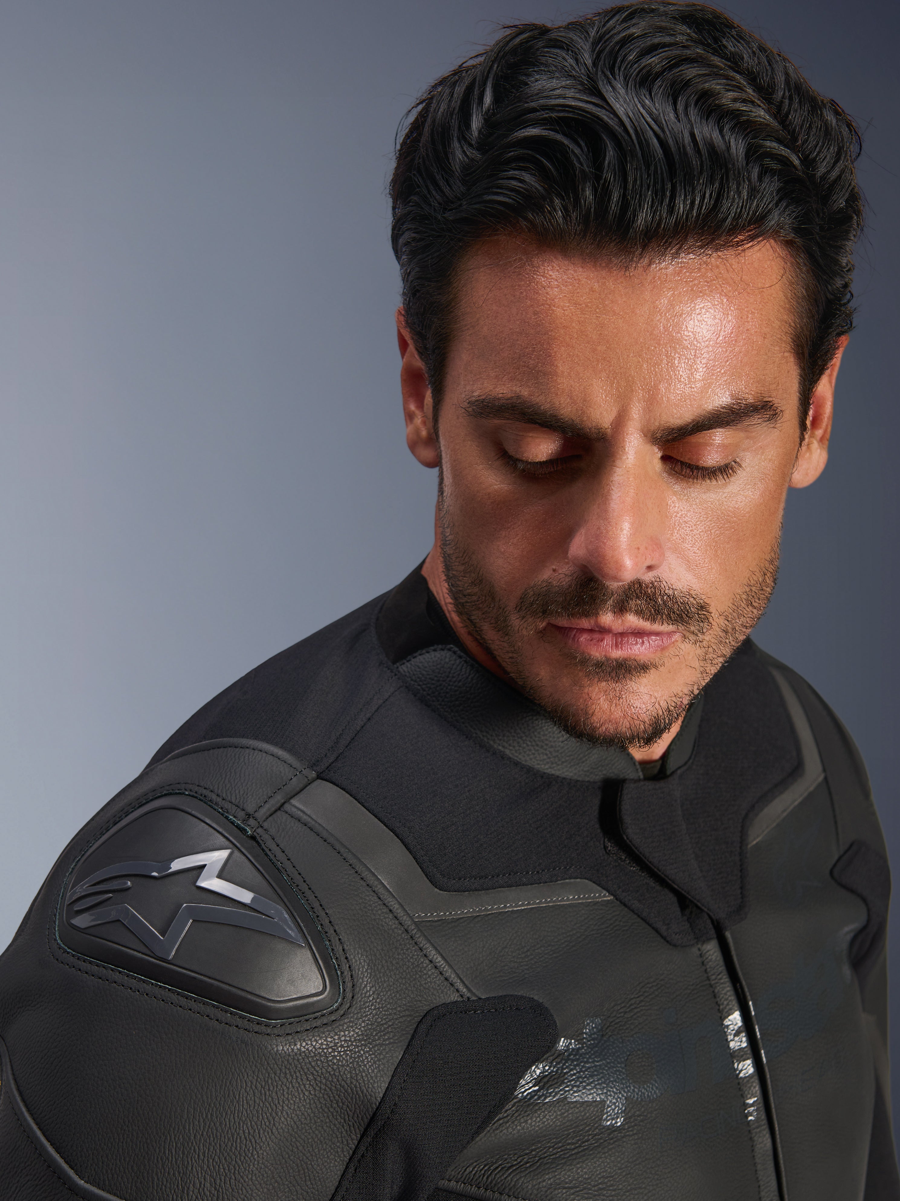 Casaco de Pele Alpinestars GP Force V2, preto, grande plano de um modelo masculino a usar o casaco, com foco no ombro com o protetor GP Lite Evo DFS e o logótipo Alpinestars, construção premium em pele multi-painel