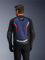 Rear view of the Alpinestars GP Force V2 Leather Jacket in Black, Blue, and Red Fluo, featuring a large blue back panel with fluorescent red and light blue accents, white Alpinestars logo and 'Racing Ahead' branding on the lower back, worn by a rider with black gloves and pants.