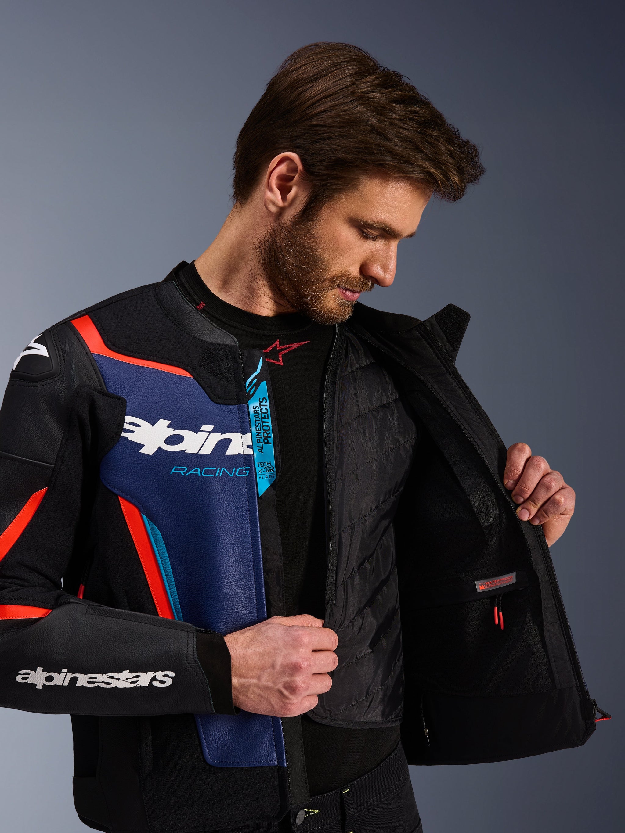 Alpinestars GP Force V2 Leather Jacket in Black Blue and Red Fluo, close-up view showing the internal detachable thermal vest and waterproof pocket, premium bovine leather with Tech-Air Ready branding, sport-optimized motorcycle apparel.