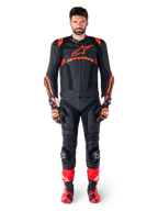 Male model wearing Alpinestars Missile V3 Ignition Leather Jacket in Black Red Fluo Dark Red, complete motorcycle racing gear including matching leather pants, racing gloves, and boots, featuring bold Alpinestars branding on the chest, forward-facing pose, professional sport riding outfit