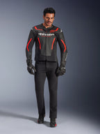 Male rider wearing Alpinestars GP Force V2 Air Leather Jacket, Black and Red Fluo, paired with black riding jeans, gloves, and shoes, featuring perforated leather construction, white logo branding, and sleek red accents for a sport-oriented look