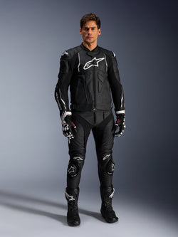 Alpinestars Missile V3 Leather Pants, Black, worn by a male rider as part of a complete leather motorcycle racing outfit, featuring white Alpinestars branding, protective knee sliders, racing boots, and gloves.