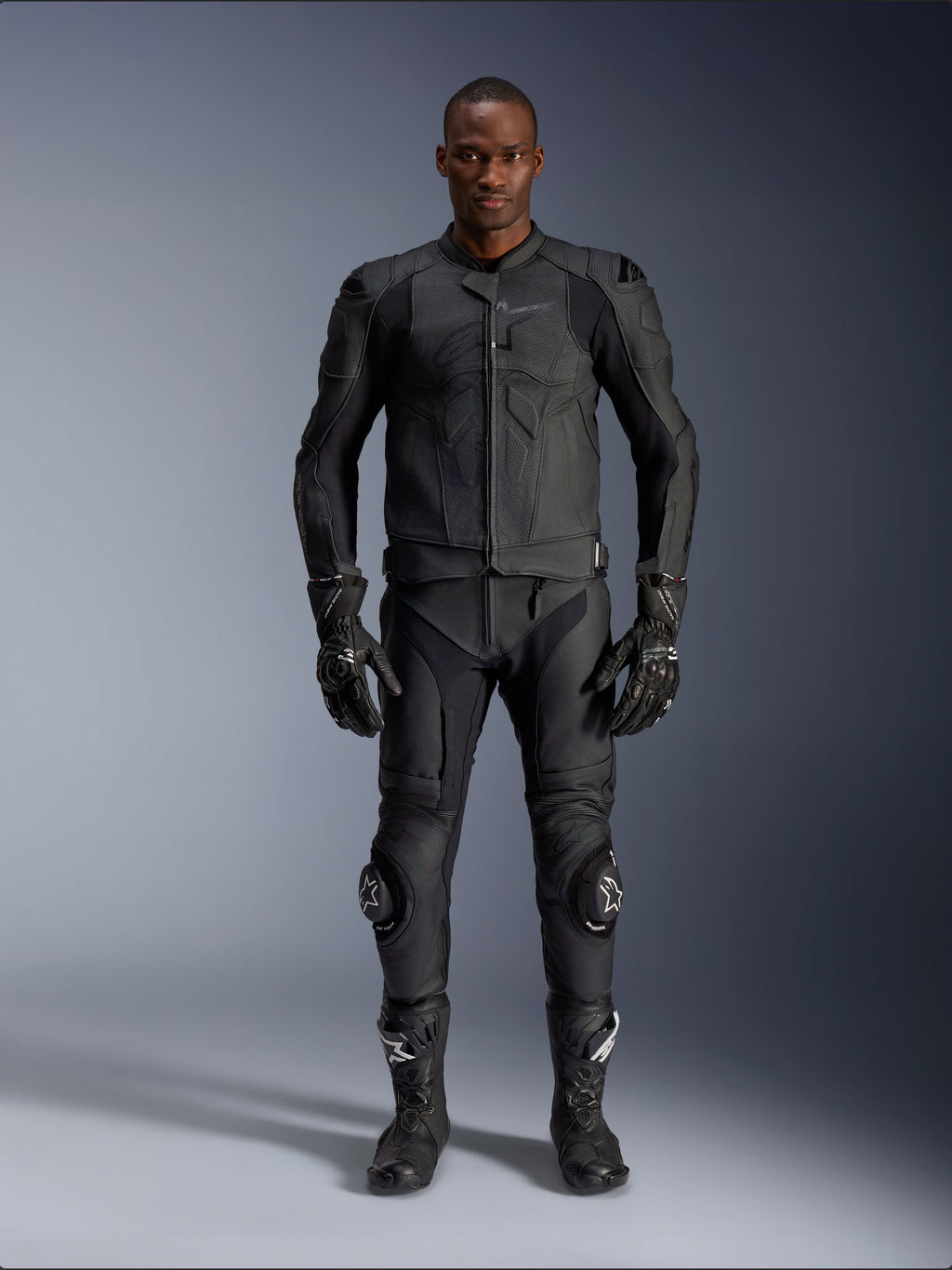 Alpinestars Dusk Airflow Leather Jacket, Black, worn with matching motorcycle pants, gloves, and boots, featuring perforated leather for maximum airflow, ergonomic multi-panel design, and internal armor, professional road and sport riding gear