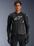 Alpinestars Dusk Airflow Leather Jacket, casaco de motociclismo em pele, preto e branco, vestido por um modelo, com painéis de pele perfurada para ventilação, logótipo branco grande no peito e sliders externos nos ombros