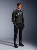 Casaco de Couro Alpinestars Dusk Airflow, preto e branco, combinado com calças de motociclismo, luvas e botas pretas, apresentando painéis de couro perfurado, logótipos brancos e estilo desportivo de estrada