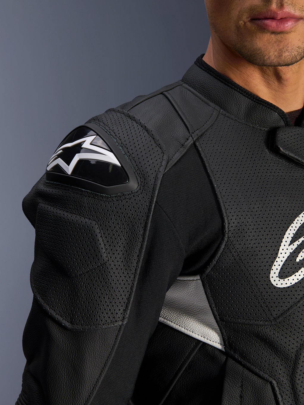 Casaco de Couro Alpinestars Dusk Airflow, preto e branco, vista detalhada do ombro e peito, com couro perfurado para ventilação, proteção de ombro DFS com logótipo Alpinestars branco e design desportivo.