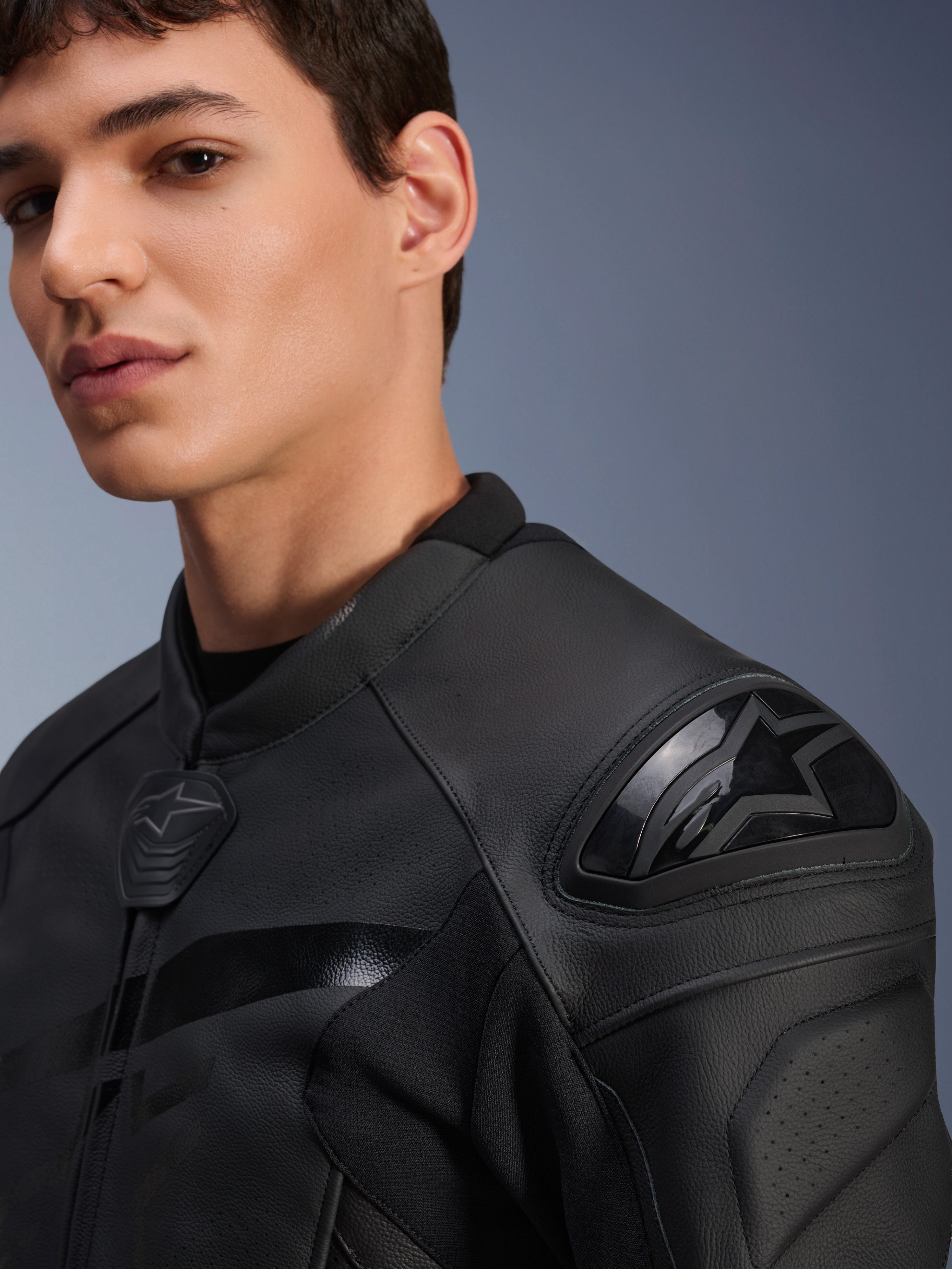 Casaco de Couro Alpinestars GP Plus R V4 Airflow, preto, grande plano de um modelo com destaque para o protetor de ombro DFS de dupla densidade e couro perfurado, equipamento profissional de condução desportiva