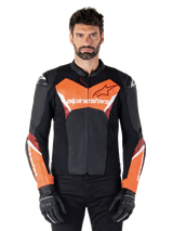 Alpinestars Faster V3 Leather Jacket, Sport Motorcycle Jacket, Black and Red Fluo, worn by a male model with black riding gloves and pants, featuring bold Alpinestars branding on chest and forearms, premium leather construction for road riding.