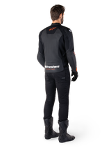 Alpinestars Faster V3 Leather Jacket, Sport Motorcycle Jacket, Black and Red Fluo, rear view worn with black pants and black boots, featuring 'alpinestars RACING AHEAD' text on the lower back and a small red star logo, sleek sport-fit leather construction