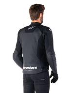 Alpinestars Faster V3 Airflow Leather Jacket, casaco de couro preto e branco, vista traseira num modelo, com costas em couro perfurado para ventilação, logótipos brancos na parte superior e na cintura com o texto 'Racing Ahead', design desportivo com painéis de estiramento para motociclismo