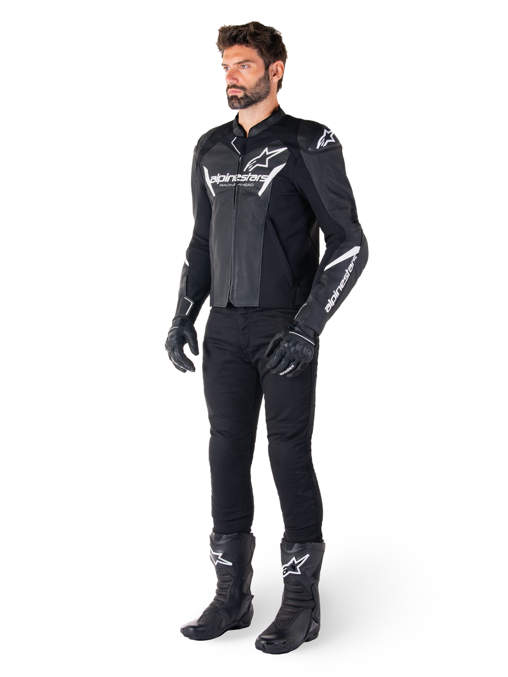 Modelo a usar o casaco de couro Alpinestars Faster V3 Airflow, preto e branco, com couro perfurado e logótipos Alpinestars brancos, combinado com calças, luvas e botas de condução pretas, equipamento de motociclismo desportivo