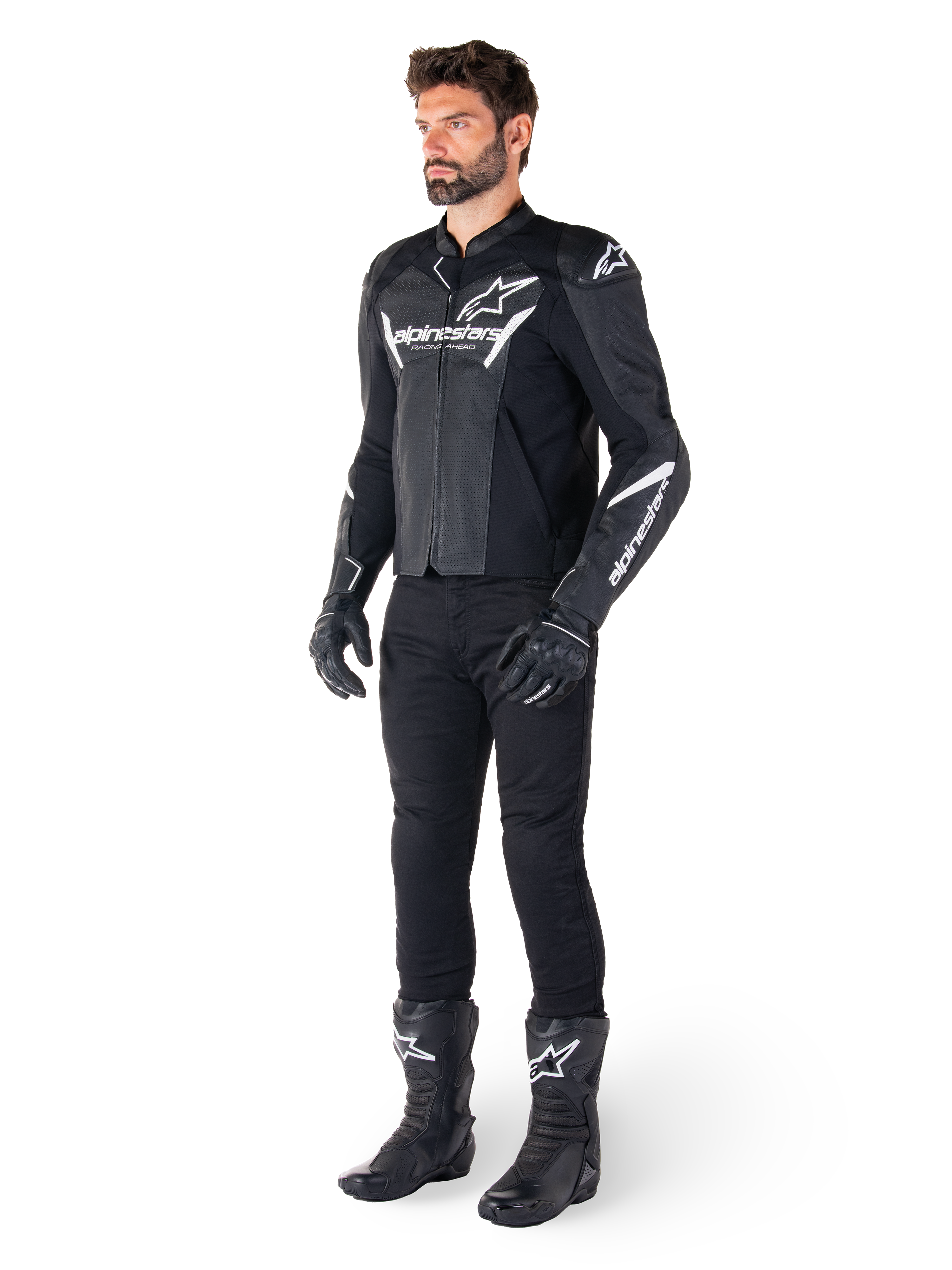 Modelo a usar o casaco de couro Alpinestars Faster V3 Airflow, preto e branco, com couro perfurado e logótipos Alpinestars brancos, combinado com calças, luvas e botas de condução pretas, equipamento de motociclismo desportivo