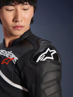 Close-up of the Alpinestars Atem V5 Leather Jacket in Black and White, featuring the DFS RR shoulder protector with white star logo, perforated leather construction, and racing-inspired chest graphics.