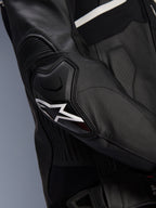 Alpinestars Atem V5 Leather Jacket, Black and White, close-up of the DFS RR elbow protector with white star logo, featuring accordion leather and perforated textures for sport riding