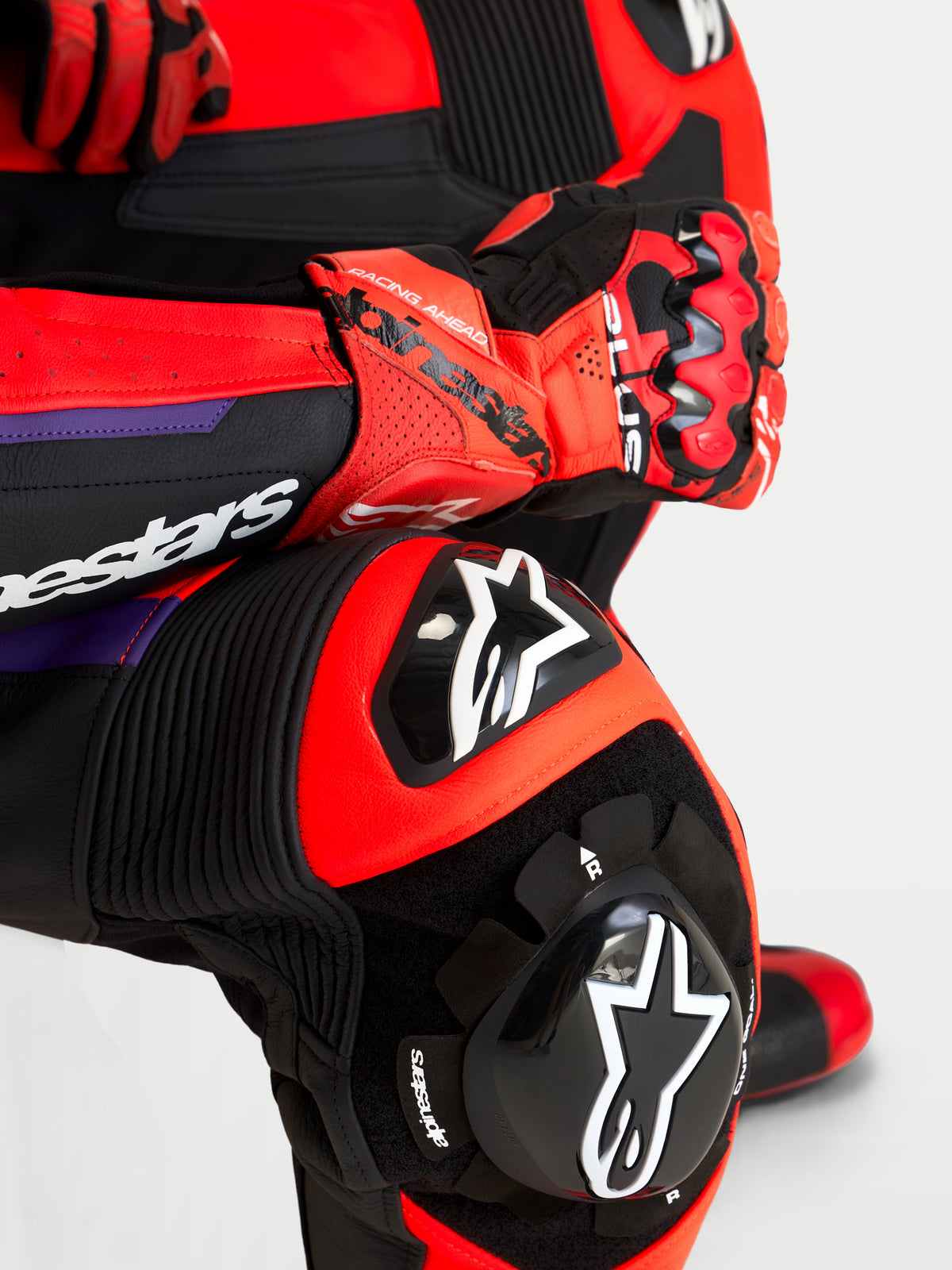Alpinestars Missile V3 Leather Suit 1 Pc, pormenor de close-up da armadura DFS ST no joelho e cotovelo, preto, vermelho e roxo, construção em couro para corrida, equipamento de proteção certificado CE