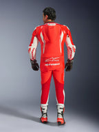 Fato de Couro GP Tech V5 de Uma Peça, fato de motociclismo, Vermelho Fluo, Vermelho Brilhante e Branco, vista traseira mostrando a corcova aerodinâmica e o logótipo Alpinestars em branco, usado com luvas e botas de corrida pretas e brancas.