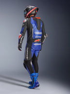 Fato de Couro Alpinestars Yamaha GP-R7 de Uma Peça, azul metálico, preto e branco, vista traseira com corcunda aerodinâmica e logótipo Yamaha, usado com botas de corrida e capacete azuis a condizer, fato de performance profissional para corridas em pista