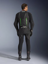 Vista traseira do Fato de Pele Alpinestars GP Force V2 de 1 Peça em preto e verde, com corcova aerodinâmica, painéis perfurados e logótipo Tech-Air Ready na zona lombar, usado com luvas e botas de corrida pretas.