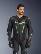 Alpinestars GP Force V2 Leather Suit - 1 Peça, fato de competição de motociclismo em preto e verde, vestido por modelo, apresentando painéis de pele perfurada, logótipo Alpinestars branco em destaque no peito e mangas, e proteção de ombros integrada para desempenho em pista.