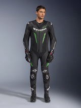 Alpinestars GP Force V2 Leather Suit - 1Piece, fato de motociclismo de uma peça, preto e verde, vista frontal de um modelo a usar o fato com logótipo branco no peito e detalhes em verde néon, com pele perfurada e deslizadores externos nos ombros, combinado com luvas e botas de corrida pretas