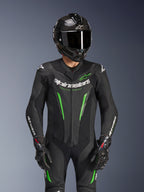 Fato de Pele Alpinestars GP Force V2 - 1 Peça, preto e verde, fato de corrida de motociclismo usado com um capacete de fibra de carbono e luvas GP Pro, com detalhes em verde lima e o logótipo Alpinestars 'Racing Ahead', concebido para o desempenho em pista.
