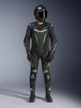 Piloto de motociclismo a usar o Fato de Pele Alpinestars GP Force V2 - 1 Peça em preto e verde, combinado com um capacete de fibra de carbono e luvas de corrida, com painéis de pele perfurada e logótipos Alpinestars brancos, equipamento profissional para pista e condução desportiva