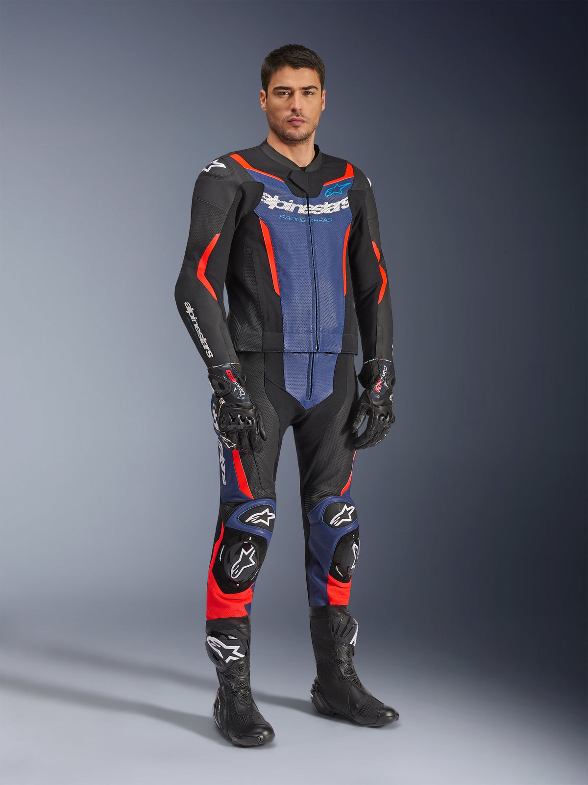 Alpinestars GP Force V2 Leather Suit 2-Piece, fato de pele para motociclismo, preto, azul e vermelho fluo, usado com luvas e botas de corrida pretas a condizer, com painéis perfurados e deslizadores de proteção, design aerodinâmico para condução desportiva