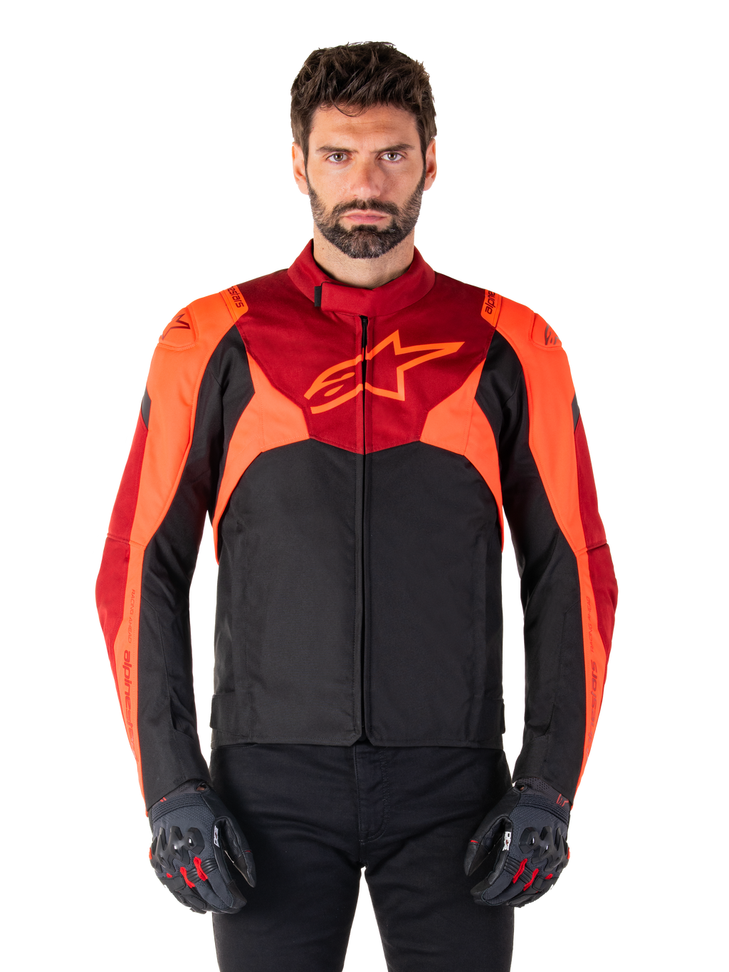Alpinestars T-Jaws V4 Waterproof Jacket, casaco de motociclismo têxtil desportivo, preto com pormenores em vermelho fluo e vermelho escuro, usado por um modelo masculino com luvas a condizer, equipamento técnico de condução com logótipo de estrela proeminente no peito.
