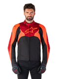 Alpinestars T-Jaws V4 Waterproof Jacket, casaco de motociclismo têxtil desportivo, preto com pormenores em vermelho fluo e vermelho escuro, usado por um modelo masculino com luvas a condizer, equipamento técnico de condução com logótipo de estrela proeminente no peito.