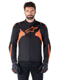 Casaco Impermeável Alpinestars T-Jaws V4, casaco desportivo de motociclismo, preto e vermelho fluorescente, com detalhes em néon e um logótipo de estrela proeminente no peito, usado por um modelo masculino com luvas de motociclismo pretas, design têxtil elegante de inspiração racing