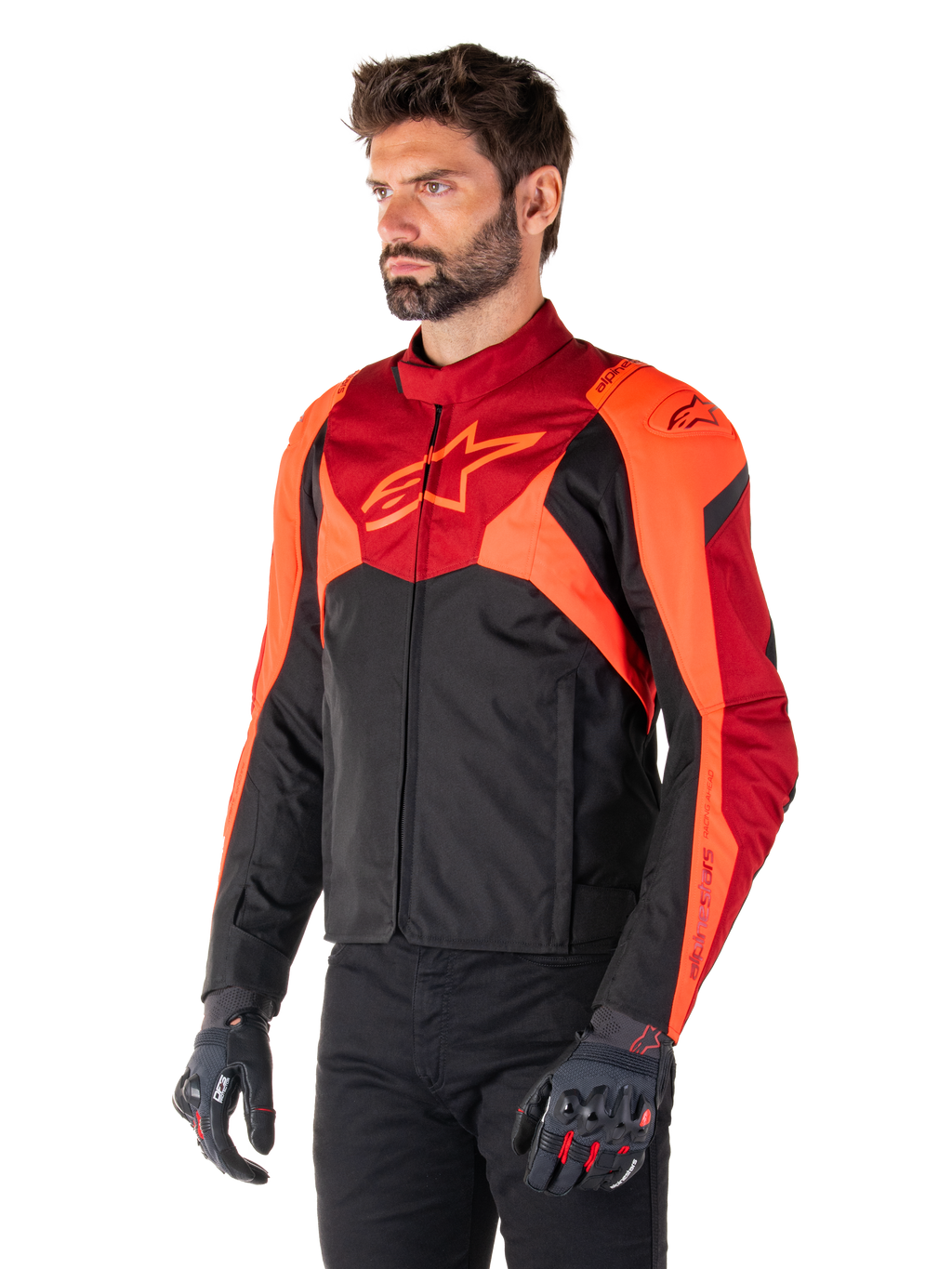 Casaco Impermeável Alpinestars T-Jaws V4, Preto, Vermelho Fluo e Vermelho Escuro, vestido por um modelo masculino com calças pretas e luvas de motociclismo, silhueta desportiva agressiva com o logótipo Alpinestars no peito, vista de três quartos