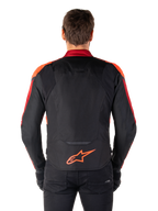 Casaco Impermeável Alpinestars T-Jaws V4, vista traseira, preto com detalhes em Vermelho Fluo e Vermelho Escuro, logótipo laranja na parte inferior das costas, painel traseiro prolongado para maior cobertura, casaco têxtil desportivo de motociclismo