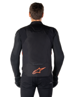 Casaco Alpinestars T-Jaws V4 Waterproof, vista traseira, preto com vermelho fluo, com um logótipo Alpinestars vermelho na parte inferior das costas, construção em tecido técnico, usado com calças e luvas pretas para um visual de condução desportivo completo